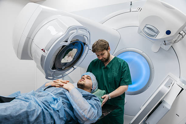 In a modern oncology clinic, a man is prepared for radiation therapy on a modern linear accelerator.