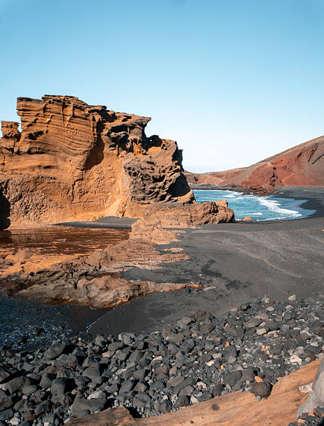 Calm bay and arid hills in rugged volcanic landscape, Lanzarote Island, Canary Islands