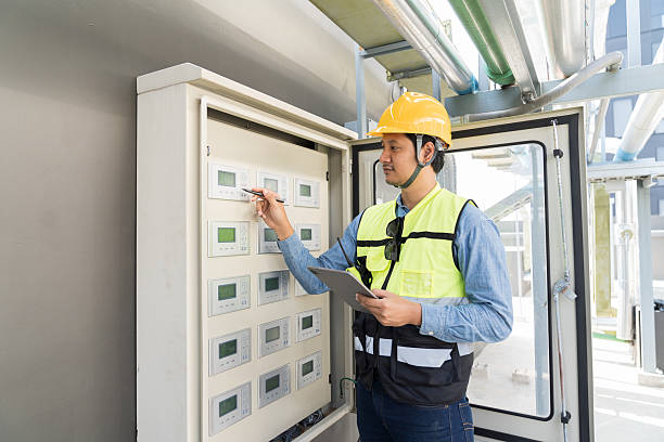 istock Electrician, Electrical system. Electrician worker maintenance operation electric system in control cabinet. Asian electrician using digital tablet for operation electric system 2211271481