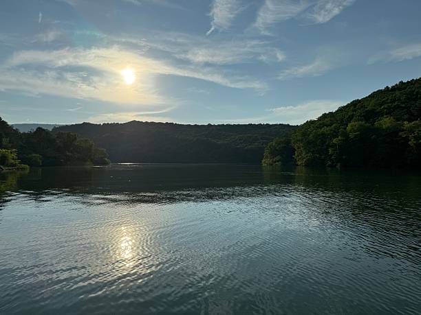 istock Serene lake view at sunset with lush hills. 2211273906