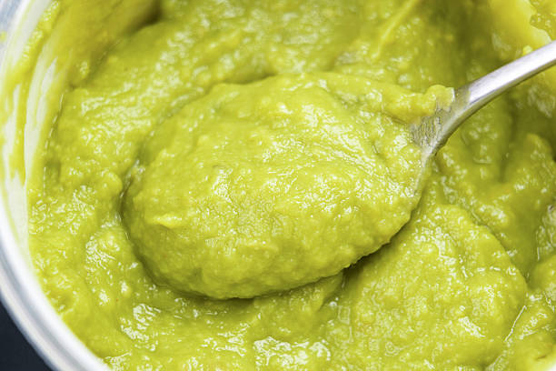 High angle view looking directly down at a bowl of fresh homemade guacamole sitting on the counter in a domestic kitchen.