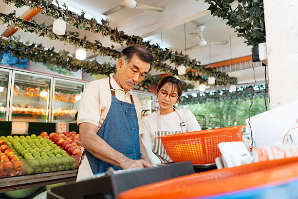 Fruit store staffs using digital scales to weight the fruit in the market