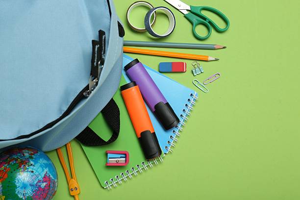 istock Backpack and different school stationery on light green background, flat lay. Space for text 2211278953