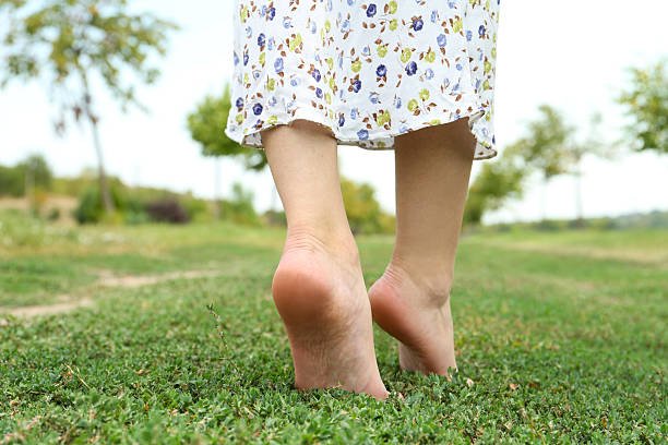 istock Woman walking barefoot on green grass outdoors, closeup 2211279100