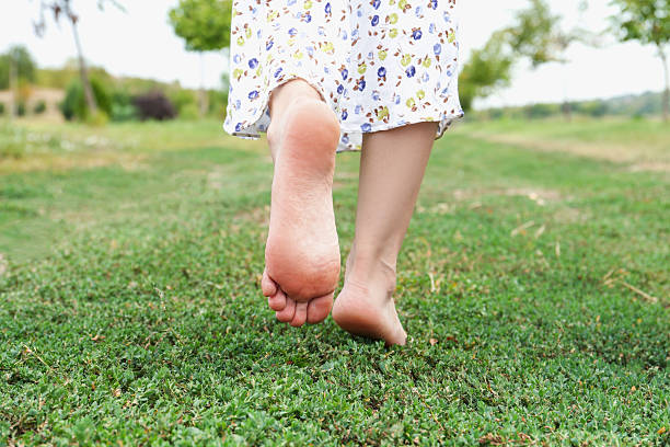 istock Woman walking barefoot on green grass outdoors, closeup 2211279142