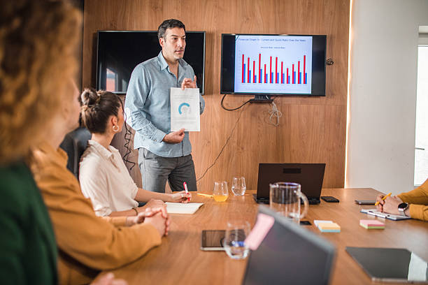 istock Concentrated businessman explaining graph to his colleagues in board room 2211280045