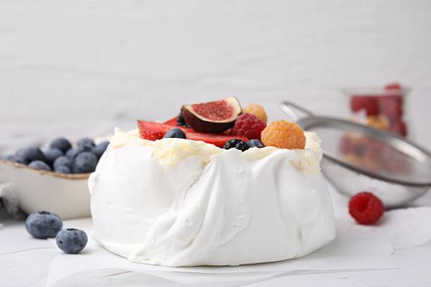 istock Pavlova cake (meringue dessert) with whipped cream, fresh berries and fig on table, closeup 2211280119
