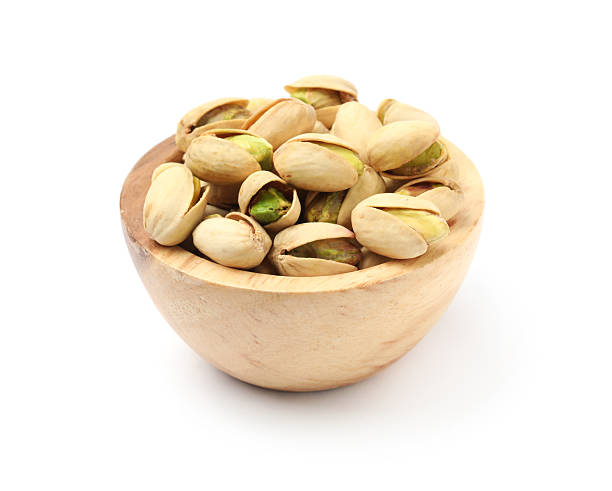istock Tasty pistachio nuts in bowl isolated on white 2211280308