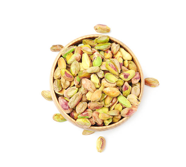 istock Peeled pistachio nuts in bowl isolated on white, top view 2211280315