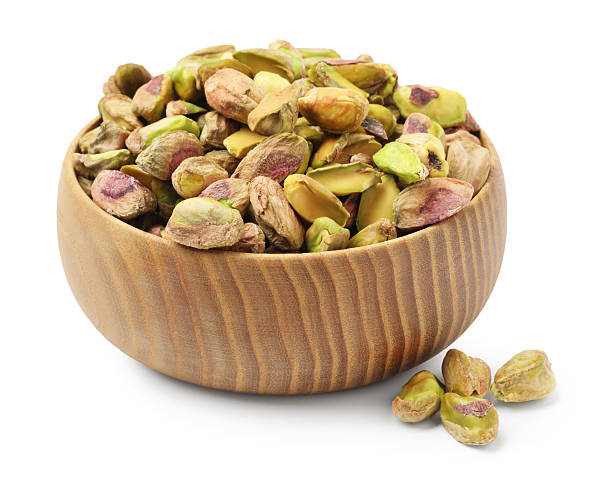 istock Peeled pistachio nuts in bowl isolated on white 2211280317