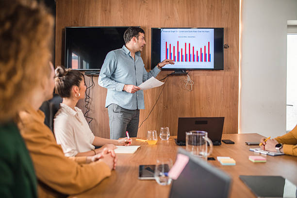 istock Focused businessman explaining graph to his colleagues in board room 2211280412