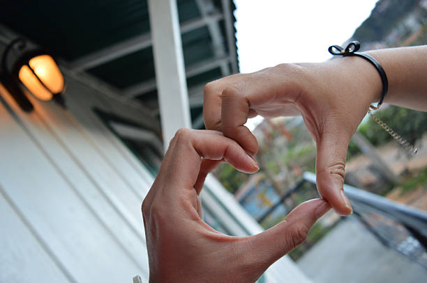 istock Macro photos of friends making heart shape from two hands 2211281993
