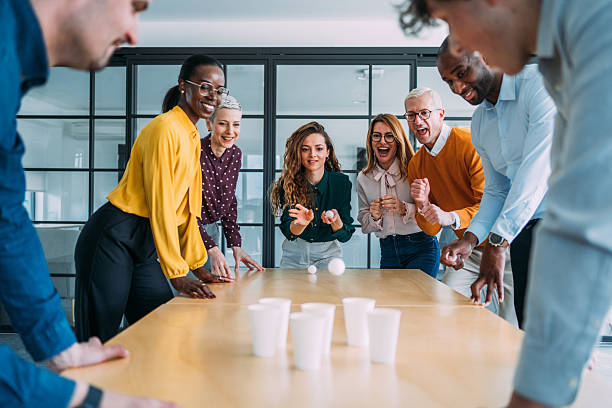 istock Young colleagues playing beer pong in the office. 2211282197
