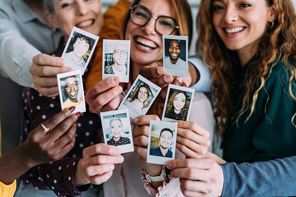 Happy colleagues making photos with instant camera.