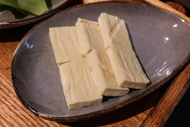 istock uncooked raw tofu ( bean curd) cut in rectangle on a plate shape for hot pot 2211284311