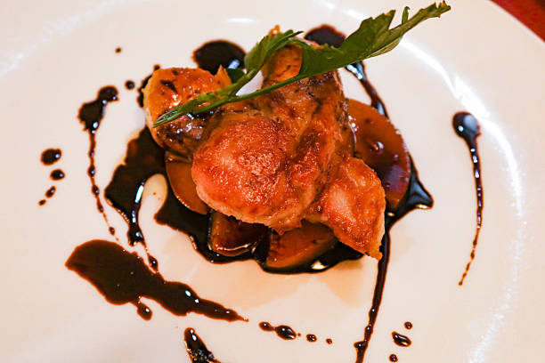 close up of Foie Gras with Caramelised Apple with black vinegar sauce on a white plate