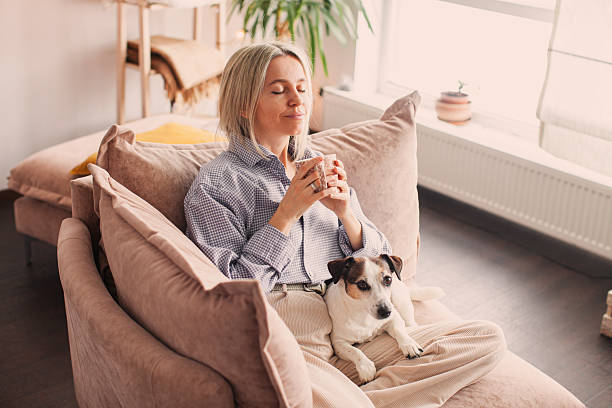 istock Cut Middle aged Woman sitting on couch at home 2211286178