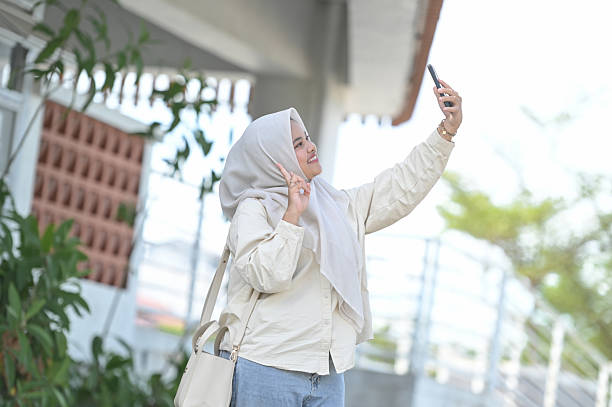 istock Asian Woman Taking Selfie with Mobile Phone Camera 2211287215