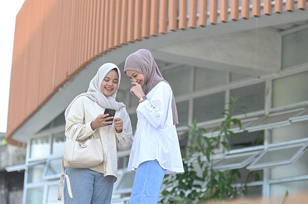 istock Two Asian women checking messages on smartphone 2211288587