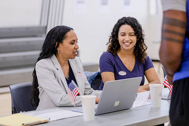 istock Two Women Working Together at Polling Place Using Laptop 2211291618