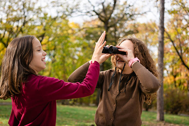 istock Two girls with binoculars having fun in nature 2211293584