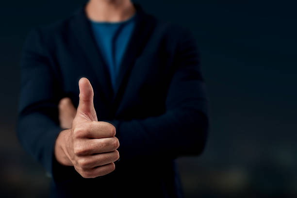 istock Man Giving Thumbs Up in Dark Background 2211294668