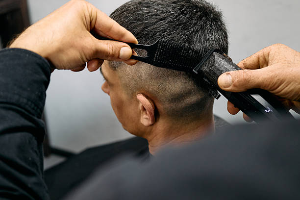 istock A barber expertly cuts a man's hair using clippers, focusing on creating a smooth fade. The salon features contemporary decor and good natural light enhancing the atmosphere 2211297873