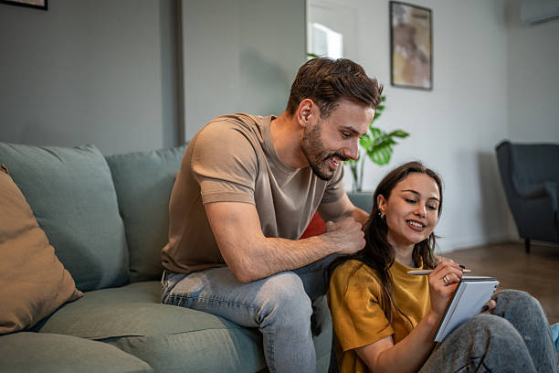 istock Young couple planning and taking notes at home 2211301382