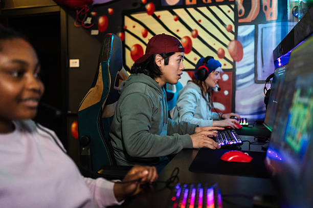 istock Gamers playing on computers in a gaming room 2211304202