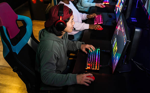 istock Young gamers playing on colorful rgb computers 2211305196