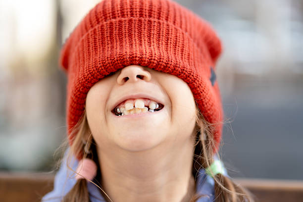 istock Happy girl with red knit hat pulled down covering eyes 2211306201