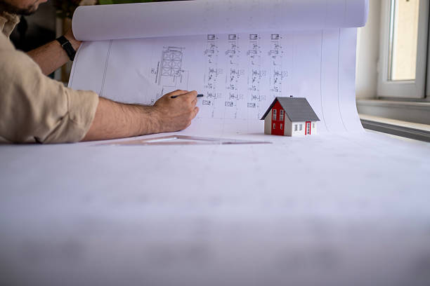 istock Architects working on construction plans in office using ruler, pencil, laptop, and calculator. 2211309162