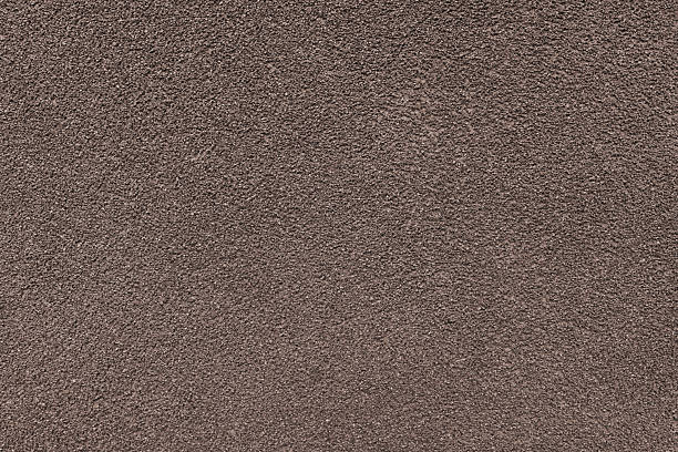 istock Grainy texture of brown colored asphalt, plaster, cement, plastic close up, macro background 2211309821