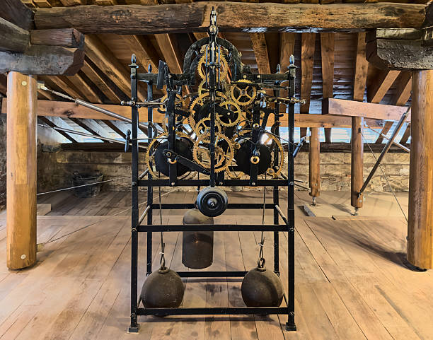 Old tower clockwork with iron gears and weights under wooden beams