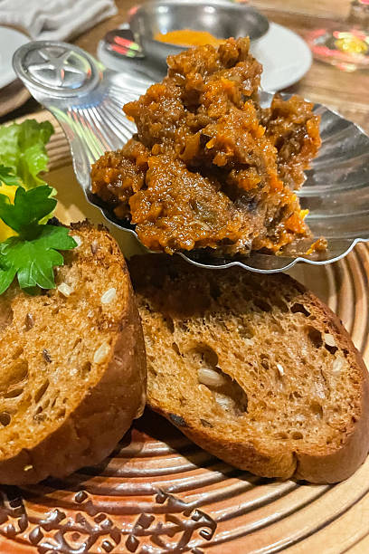 istock Eggplant caviar with toast on a wooden board, on light concrete 2211312555