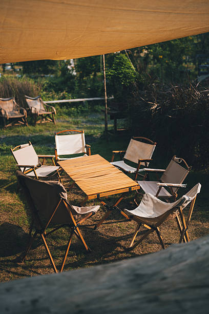 istock cozy outdoor dining area set up for a rustic BBQ party offering relaxed camp style atmosphere where friends, families gather to enjoy grilled food and create unforgettable memories under the lights 2211312837