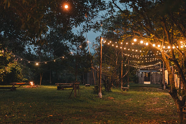 istock Cozy outdoor campfire surrounded by rustic wooden benches and glowing string lights, creating a peaceful evening atmosphere perfect for glamping under the stars in a nature-inspired forest retreat 2211313916