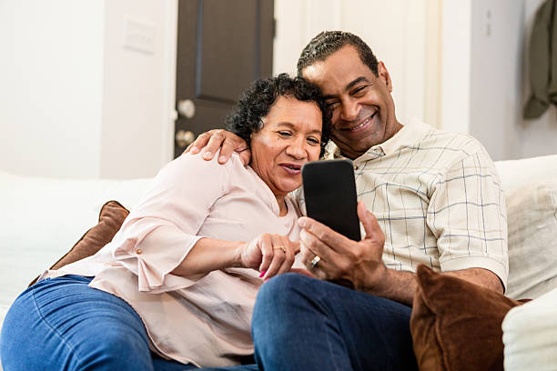 istock Happy Mature Couple Using Smart Phone Together at Home 2211314230