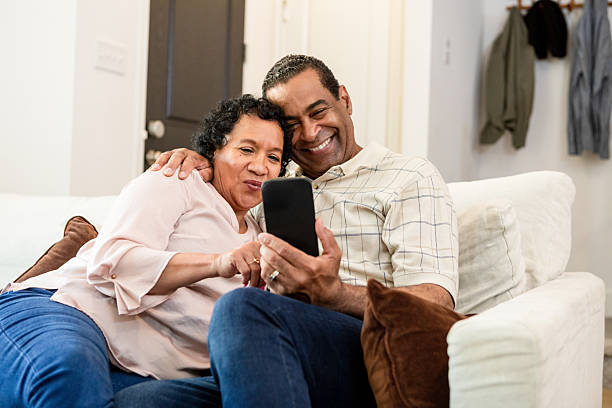 istock Happy Mature Couple Using Smart Phone Together at Home 2211314232