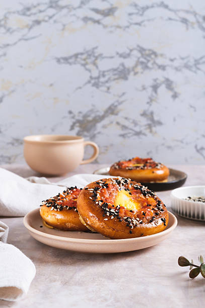 istock Baked bagels with tomato and quail egg on a plate on the table vertical view 2211315114