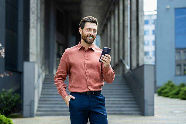 istock Confident Businessman Using Smartphone While Standing Outside an Office Building 2211316671