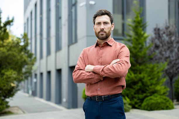 istock Serious confident businessman outside office building, successful man looking at camera with arms crossed 2211317041