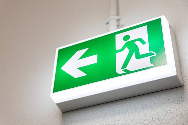 istock Fire Emergency exit sign on the wall background inside building. Safety concept 2211320898