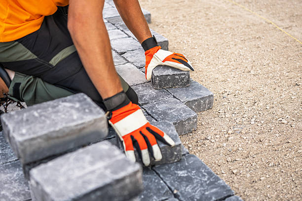 istock Worker Laying Stone Blocks for Outdoor Pathway Construction 2211321891