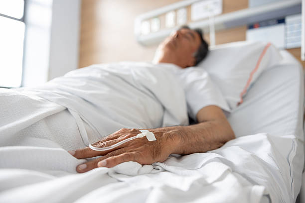 istock Senior man lying in bed at the hospital 2211322441