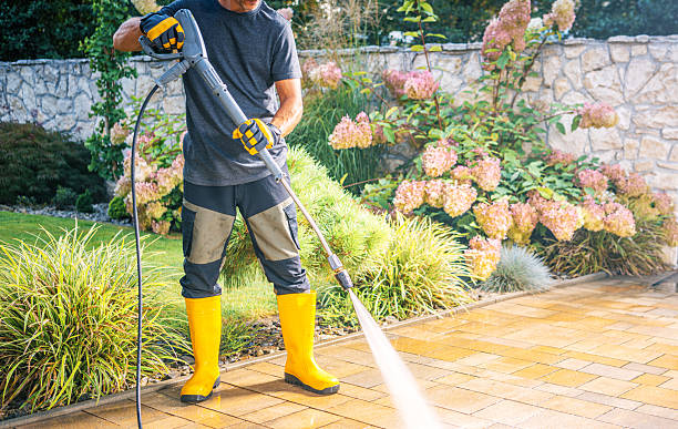 istock Man Using Pressure Washer to Clean Patio in Garden 2211323437