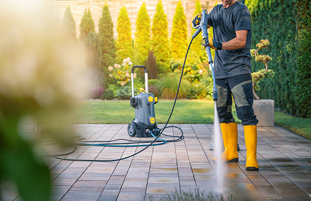 istock Man Using Pressure Washer to Clean Patio in Sunny Garden Setting 2211323537