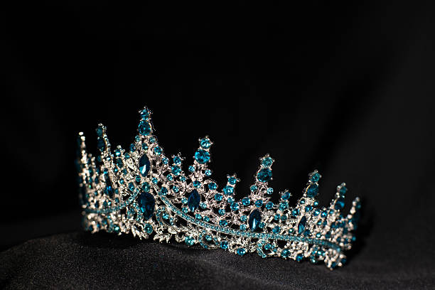 istock Royal crown with blue topaz on black background 2211324881
