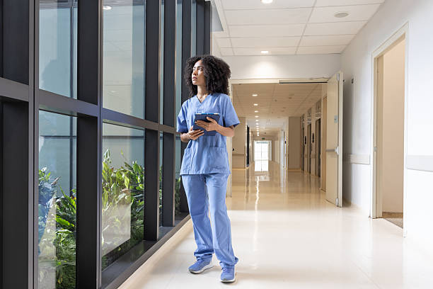istock Nurse holding a digital tablet at the hospital while looking through a window 2211325551