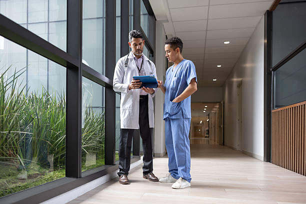 istock Doctor talking to a male nurse while looking at test results on a tablet 2211325572